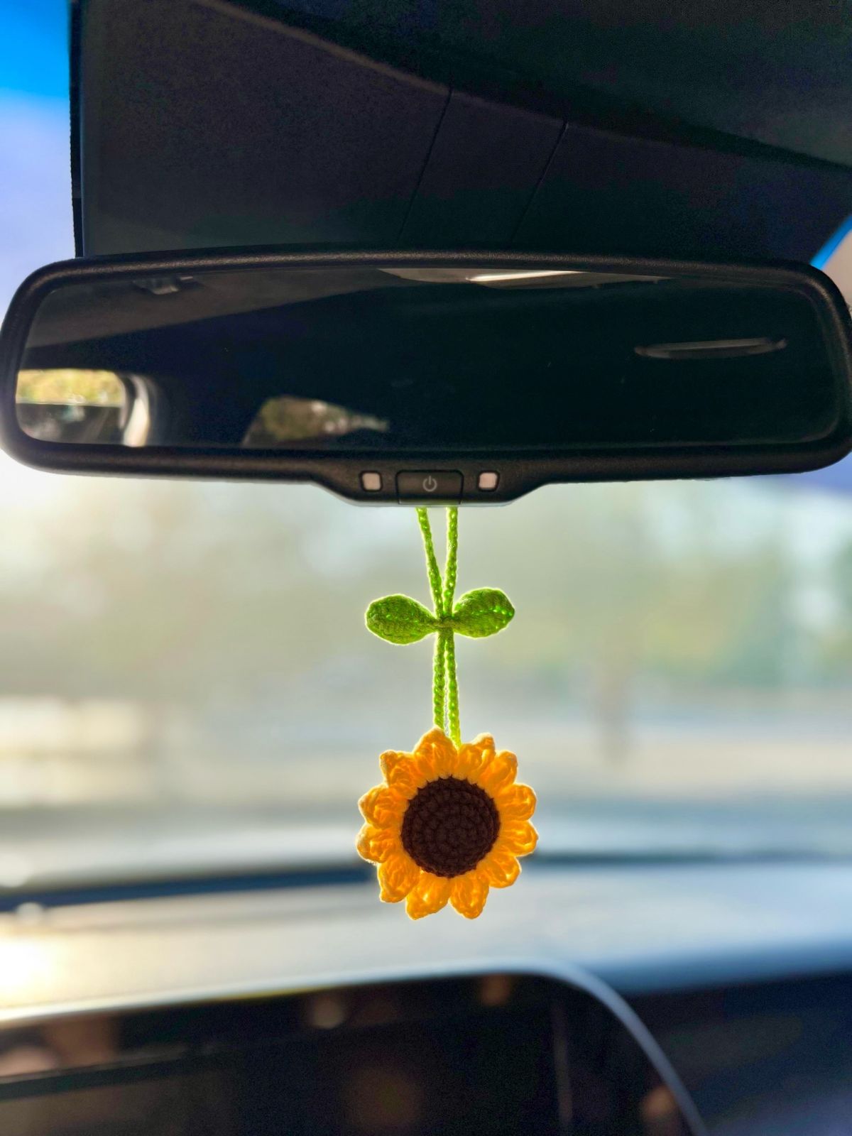 Hand-crocheted sunflowers arranged in a small glass vase.
